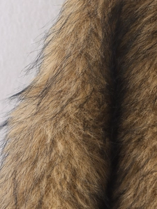 Gros plan détaillé de la texture de fourrure synthétique brune et noire d'une veste