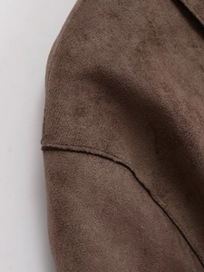 Detailed macro view of dark brown suede fabric texture and fine stitching on jacket