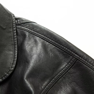 Detail of double-stitched shoulder seam and collar on vintage-style black PU leather jacket