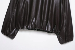 Detailed view of elastic cuffs and hem on a vintage dark brown faux leather pilot jacket