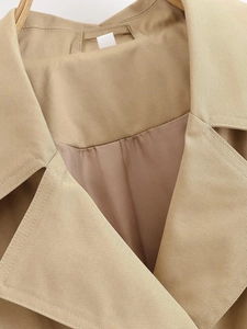 Macro detail of khaki trench coat collar featuring fine twill texture and smooth lining