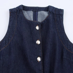 Detail der dunkelblauen Denim-Weste mit Silberknöpfen und orangen Kontrastnähten