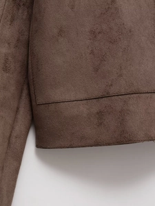 Detail of dark brown suede fabric texture and precise stitching on the vintage jacket
