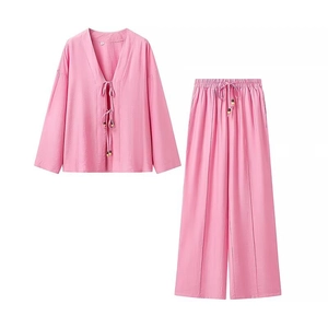 Detail of pink two-piece set featuring lace-up V-neck top with wooden beads and linen texture
