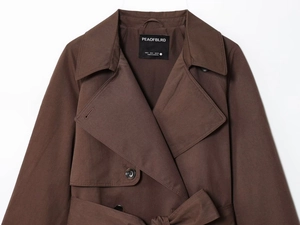 Close-up of lapel and button detail on dark brown cotton blend trench coat