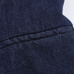 Detailaufnahme der dunkelblauen Denim-Stoffstruktur mit feiner Nahtverarbeitung