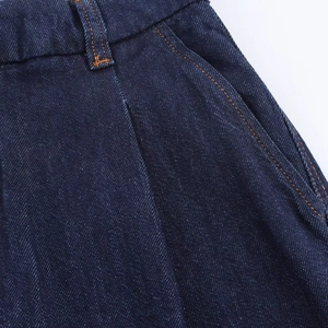 Detail von dunkelblauem Denim mit orangefarbenen Kontrastnähten und Seitentaschendesign