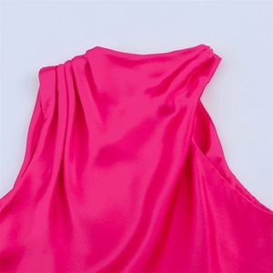 Détail du décolleté drapé d'une robe de soirée sans manches en satin rose vif