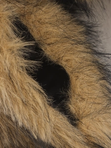Vue détaillée d'une veste en fausse fourrure montrant la texture et les poignets