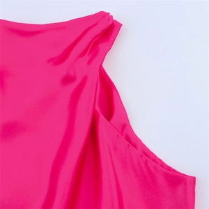 Détail de la robe en satin fuchsia montrant l'épaule asymétrique et la texture soyeuse