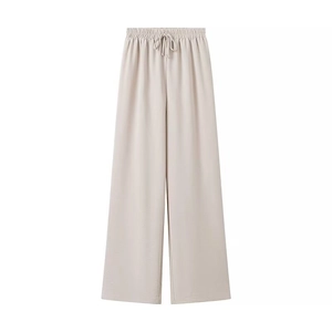 Detail of high-waist beige wide-leg pants featuring elastic waistband and drawstring ties