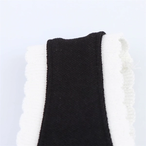 Macro detail of contrast knit fabric showing black texture and white ribbed ruffled edges