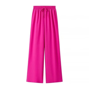 Detail of fuchsia wide-leg trousers featuring elastic drawstring waist and textured fabric