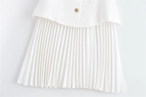 Détail d'une robe plissée blanche avec bouton doré et design de taille multicouche élégant