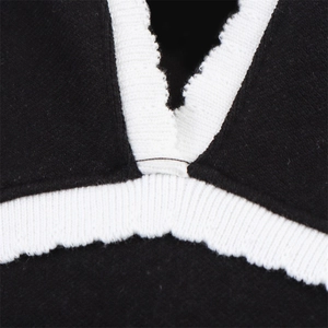 Detail of black felt fabric with white ribbed knit neckline and contrast stitching finish