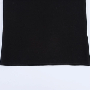 Detailed close-up of neat stitching and hem on soft black knitted fabric garment