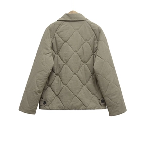 Back view of khaki quilted jacket with large diamond patterns and wood hanger