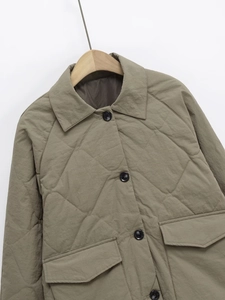Detailed view of khaki quilted jacket featuring large pockets and button-down collar