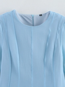 Close-up of light blue layered ruffle dress showing neckline stitching and S-size label
