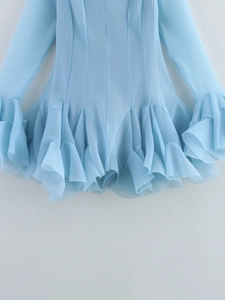 Detailed view of layered ruffles on the light blue long sleeve dress with textured fabric