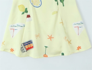 Detailed view of yellow dress hem featuring vibrant Italian style lemon and floral prints