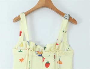Detail view of yellow floral dress showing cherry print and back lace-up zipper