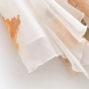 Détail du tissu en mousseline blanche avec imprimé floral orange pour une robe d'été élégante