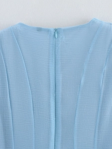 Detailed view of light blue pleated chiffon fabric with a hidden back zipper closure