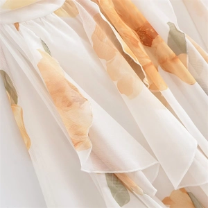 Détails de l'imprimé floral orange et des volants sur une robe légère en mousseline