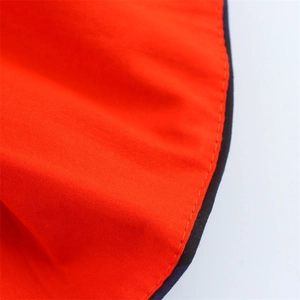 Detailed view of high-quality orange fabric stitching and black trim on a high waist skirt