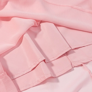 Detailansicht der rosa Chiffon-Stofflagen und des Innenfutters dieses eleganten Kleides