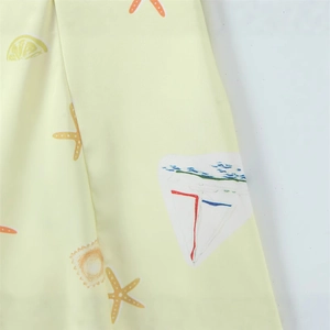 Close-up of slim-fit dress fabric with nautical starfish, lemon and sailboat prints