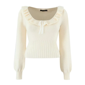 Detail of knit sweater showing ruffled neckline and white ribbon bow tie feature