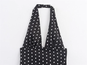 Dettaglio dell'abito nero a pois con scollo all'americana e chiusura a doppio bottone