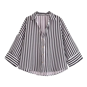 Detailed view of the black and white striped shirt fabric with rustic wooden buttons