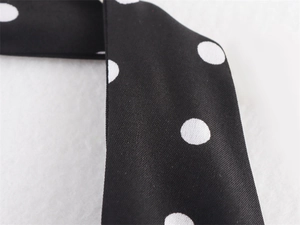 Vista macro di tessuto nero a pois bianchi con trama di tessitura dettagliata e finitura
