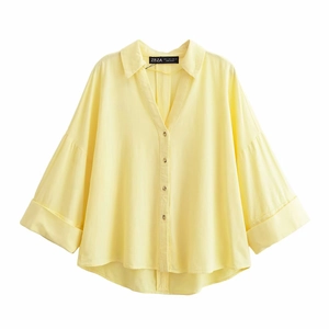Macro detail of V-neck collar and ZBZA brand label on yellow loose casual shirt