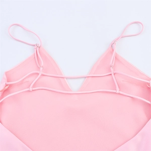 Detail of light pink satin camisole showing delicate thin straps and cross back design