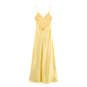 Detail of light yellow satin dress featuring cross thin straps and elegant open back design