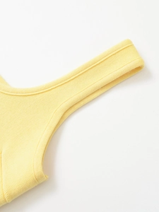 Dettaglio ravvicinato di un top in maglia a coste giallo brillante con cuciture rifinite