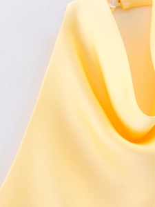 Detailansicht des hellgelben Satin-Oberteils mit drapiertem Ausschnitt und Knopfverschluss