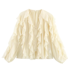 Detail view of cream V-neck shirt featuring elegant ruffled layers and button closure