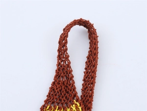 Gros plan sur le tricot rouge rouille et jaune avec maille ajourée et texture artisanale