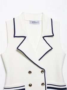 Detail view of double-breasted knit vest with contrast trim and gold metal buttons