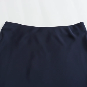 Macro shot of navy blue satin skirt waistline with smooth texture and clean finish