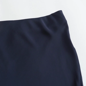 Detail of high waist seamless waistband on dark blue satin texture maxi skirt