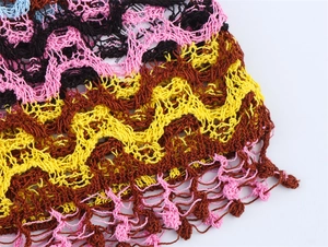 Gros plan d'un tissu en maille multicolore avec texture ondulée et bordure en dentelle
