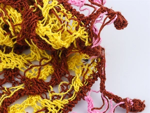Gros plan sur un tricot ajouré multicolore avec des fils jaune vif et rose