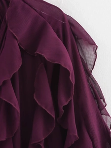 Detailed close-up of layered ruffles on a dark purple chiffon blouse with elegant texture