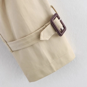 Close-up of khaki trench coat cuff with high-density twill fabric and brown buckle